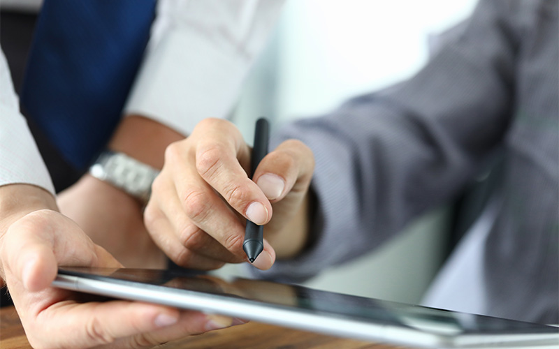 Person signing or reviewing a document on a tablet with a stylus